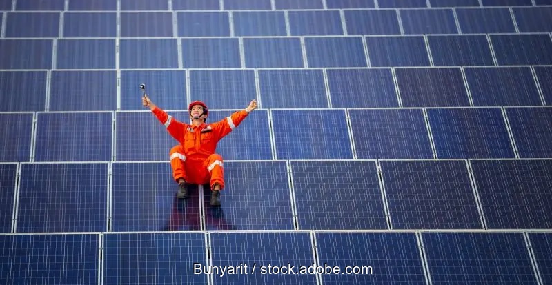 Zu sehen ist ein Arbeiter inmitten von PV-Modulen. Größter Solarpark Europas bei Leipzig geplant.
