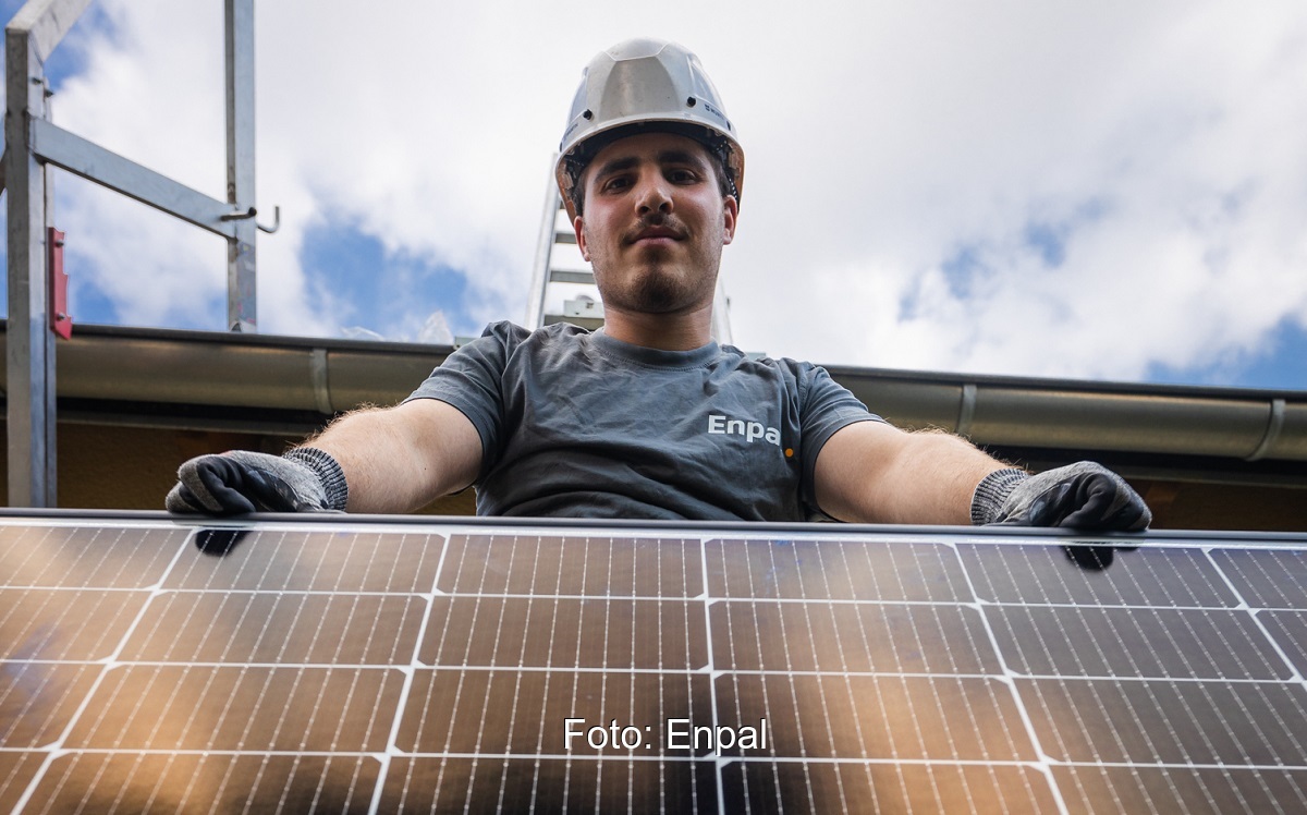 Im Bild ein Enpal Monteur mit einem Solarmodul, das Unternehmen bietet jetzt auch Photovoltaik für Gewerbekunden an.