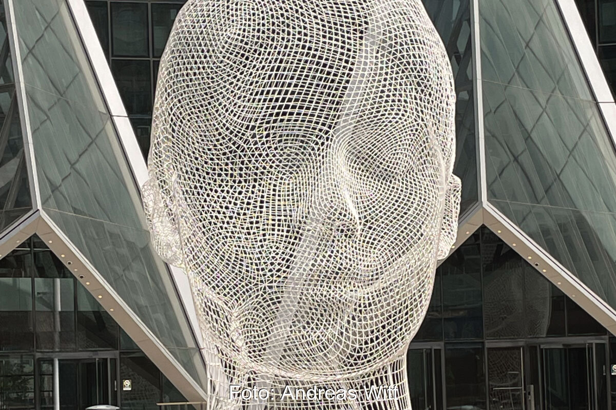 Kunst am Bau: Ein überdimensionaler Menschlicher Kopf aus weißem Maschenwerk geformt.