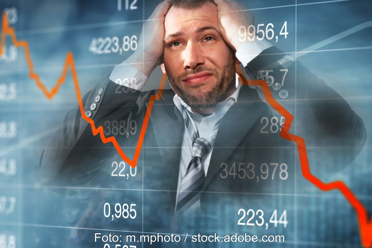 Fotomontage zeigt verzweifelten Händler vor einem Hintergrund mit abstürzender Börsenkurve.